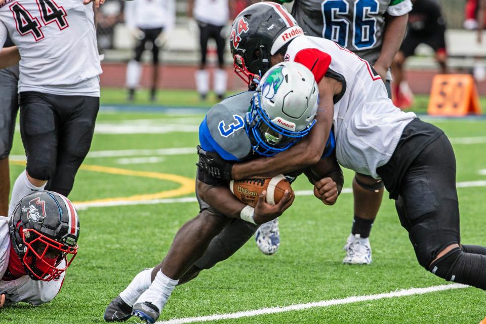 St. Georges senior Terry White (3) hangs on to the ball against the takedown by William Penn senior Isaiah Davis (24) during the football game at St. Georges in Middletown, Saturday, Sept. 30, 2023. St. Georges won 20-19.