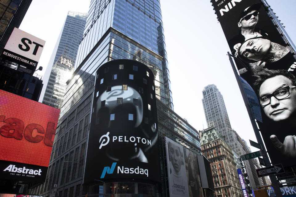 The Peloton logo is displayed, center, on the Nasdaq MarketSite, Thursday, Sept. 26, 2019 in New York's Times Square. (AP Photo/Mark Lennihan)