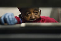 Hosea Knox, owner of Elmo's Tombstones, looks over a work order Thursday, May 28, 2020, for the next stone in his shop on Chicago's Southside. The process of transcribing begins as a collaboration between the deceased's family and Knox. (AP Photo/Charles Rex Arbogast)