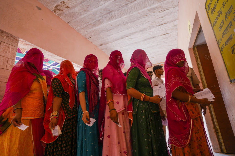 Women queue up to cast their vote during the second phase of polling in the six-week long national election in Barmer district, western Rajasthan state, India, April 26, 2024. Misinformation about India's election is surging online as the world's most populous country votes. The country has a huge online ecosystem, with the largest number of WhatsApp and YouTube users in the world. Nearly 1 billion people are eligible to vote in the multiphase election that ends next month.(AP Photo/Deepak Sharma)
