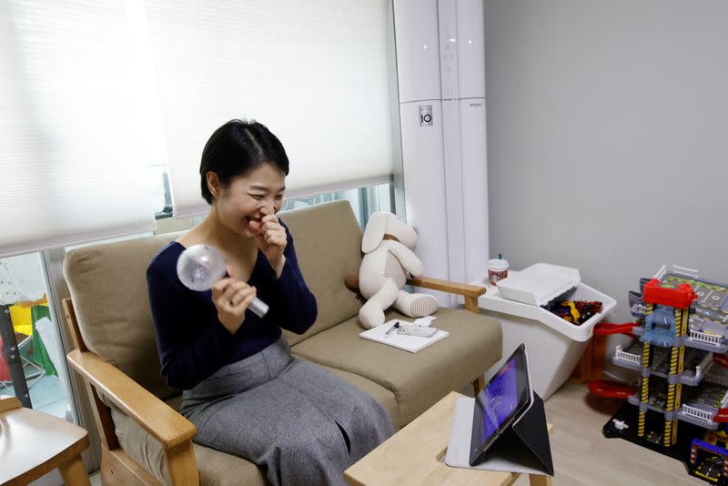 Emily Seo, fan of K-pop boy band BTS, watches a video clip of BTS performance at her home in Seoul