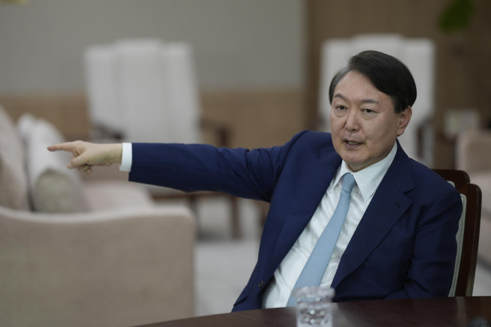 South Korean President Yoon Suk Yeol points to a white telephone on desk that he said is meant for a direct hotline communications channel with the North Korean leader, during an interview at the presidential office in Seoul, South Korea, Tuesday, Jan. 10, 2023. (AP Photo/Lee Jin-man)