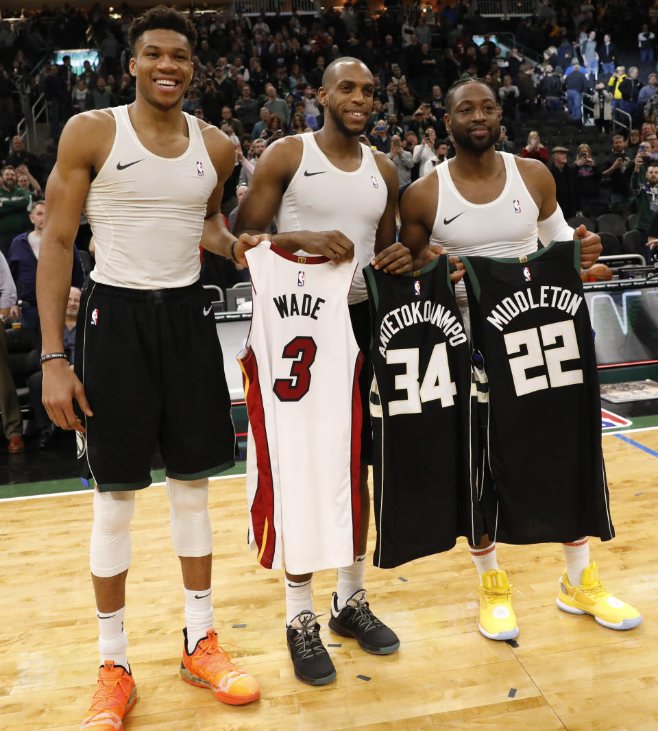 Milwaukee Bucks' Giannis Antetokounmpo, left, and Khris Middleton, center, swap jerseys with Miami Heat's Dwyane Wade after an NBA basketball game Friday, March 22, 2019, in Milwaukee. (AP Photo/Jeffrey Phelps)