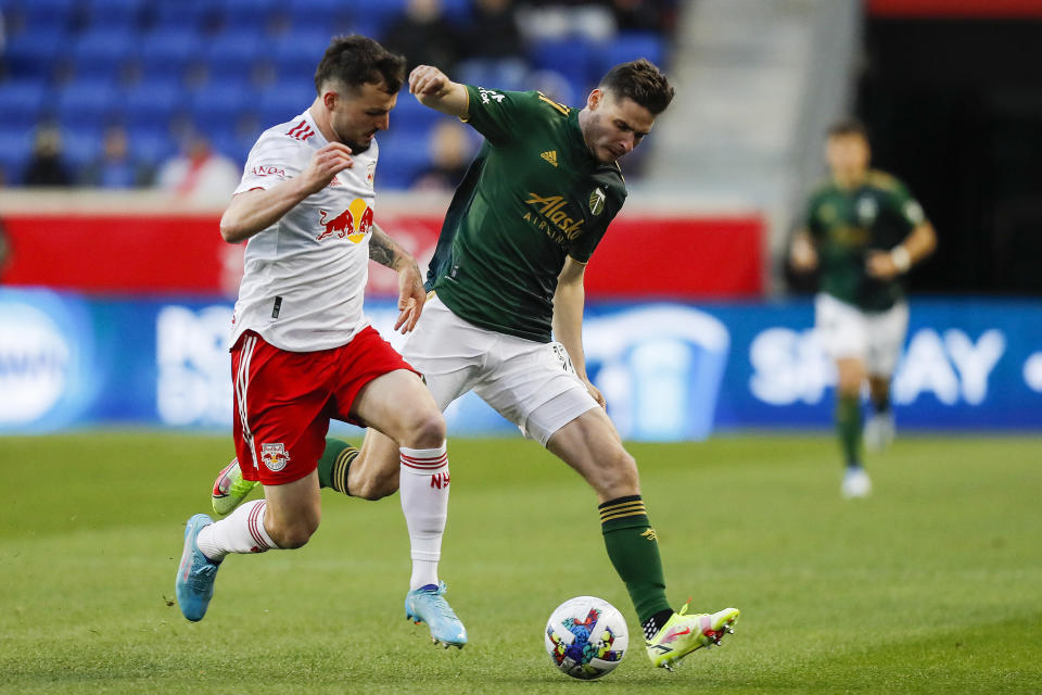 New York Red Bulls forward Ashley Fletcher, left, fights for the ball against Portland Timbers forward Jaroslaw Niezgoda, front right, during the first half of an MLS soccer match, Saturday, May 7, 2022, in Harrison, N.J. (AP Photo/Eduardo Munoz Alvarez)