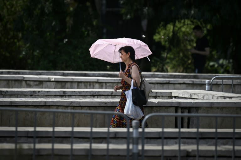 Una mujer se protege del calor con un paraguas en el centro de Sofia el 18 de julio de 2024 (Nikolay DOYCHINOV)