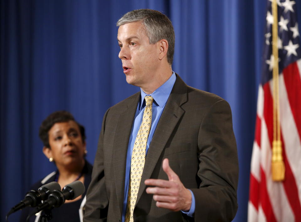 U.S. Secretary of Education Arne Duncan (R) answers questions at a news conference at the Justice Department in Washington November 16, 2015. U.S. Attorney General Loretta Lynch listens at left.  REUTERS/Gary Cameron    