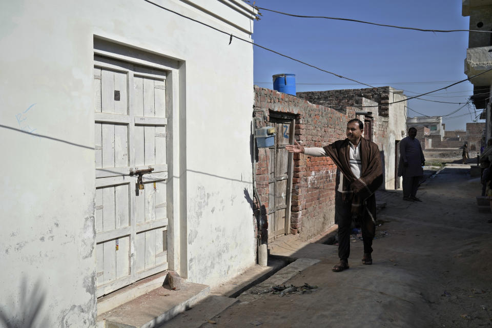 Zahid Hashmi gestures toward the house of Waris, a blasphemy suspect who was lunched by an angry mob, in Warburton, an area of district Nankana, Pakistan, Sunday, Feb. 12, 2023. Hundreds of Muslims descended on a police station in Pakistan's eastern Punjab province Saturday, snatched Waris, a blasphemy suspect from his cell and took him outside and lynched him, police said. (AP Photo/K.M. Chaudary)