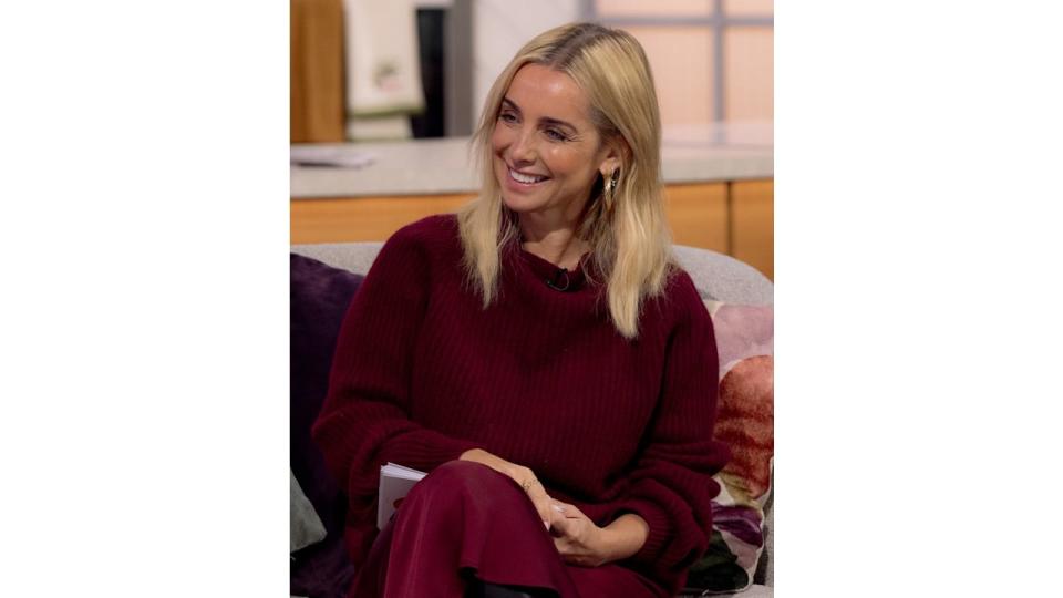 Louise Redknapp smiling in a red jumper