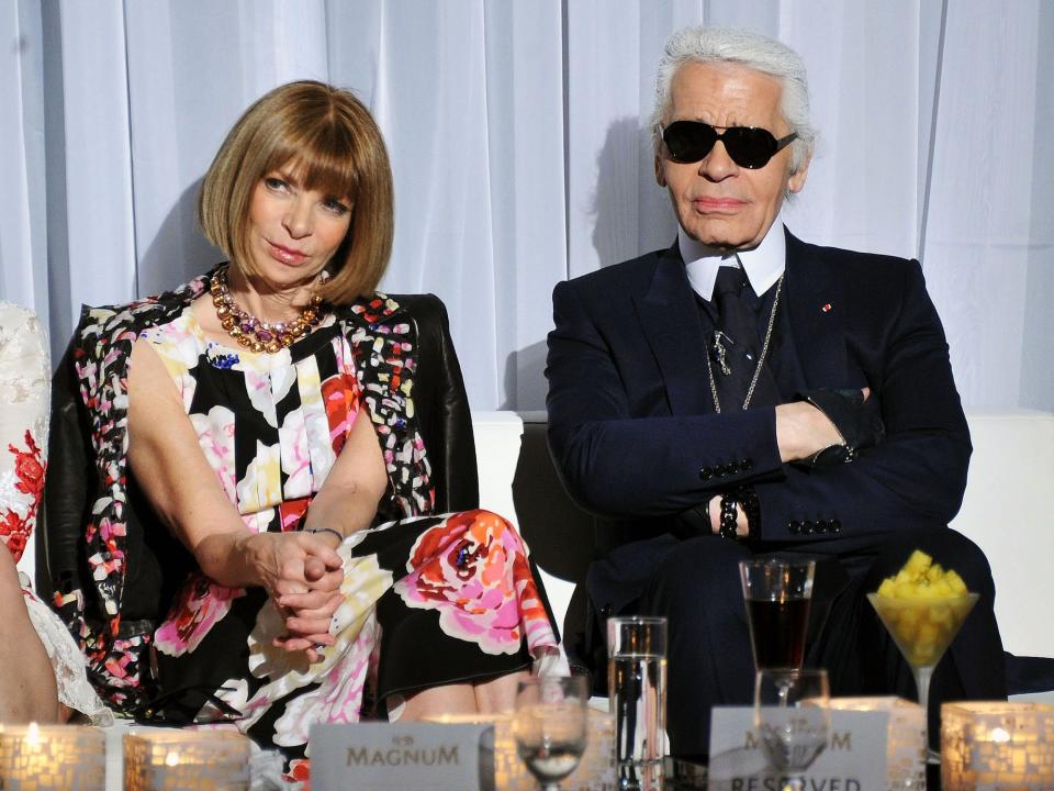 Anna Wintour and Karl Lagerfeld sit on a bench.