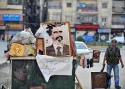 A Syrian rebel stands near a vandalized portrait of Syrian President Bashar al-Assad during clashes between rebels and Syrian troops in the city center of Selehattin, near Aleppo. Syria admitted Monday it has chemical weapons and warned of using them if attacked, though not against its own civilians, as regime troops reclaimed most of Damascus after a week of heavy clashes