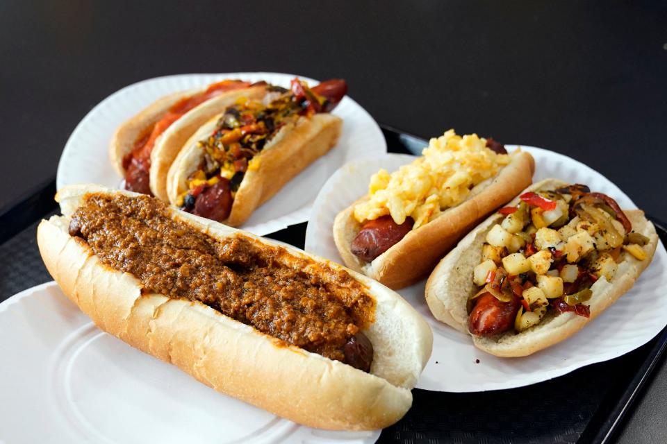 Pictured front is the Hackensack Hotdog with a jumbo bacon-wrapped hotdog deep-fried and topped with a chili sauce, along with other specialty hotdogs at Hackensack Hotdogs on State street on Thursday, June 22, 2023.