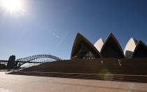 Dos turistas contemplan la Ópera de Sídney (Australia) el 20 de marzo. (Foto: Peter Parks / AFP / Getty Images).