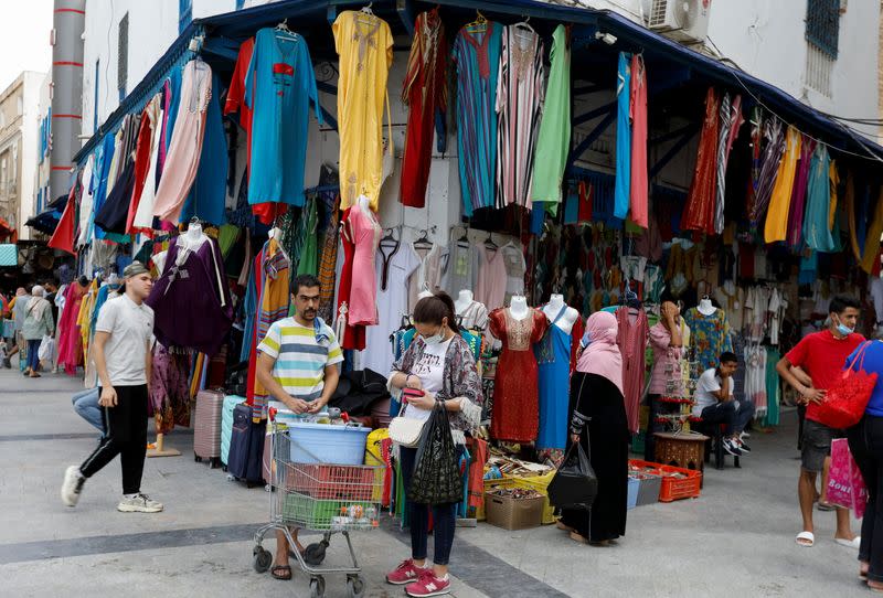 People walk past shops in the center of Tunis