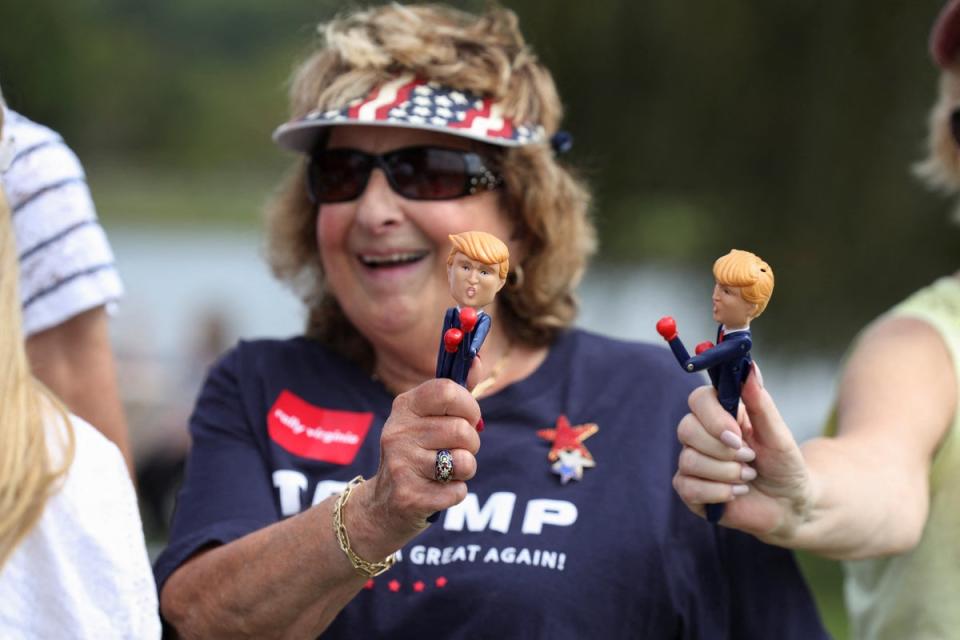 A Trump supporter holds a figurine of the former president at his Wilmington, North Carolina, rally on Saturday. Some have wondered if Trump fatigue is setting in for some voters (REUTERS)