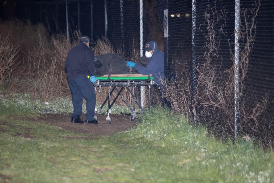 Workers remove the body from Howard Beach on Friday night. Robert Mecea