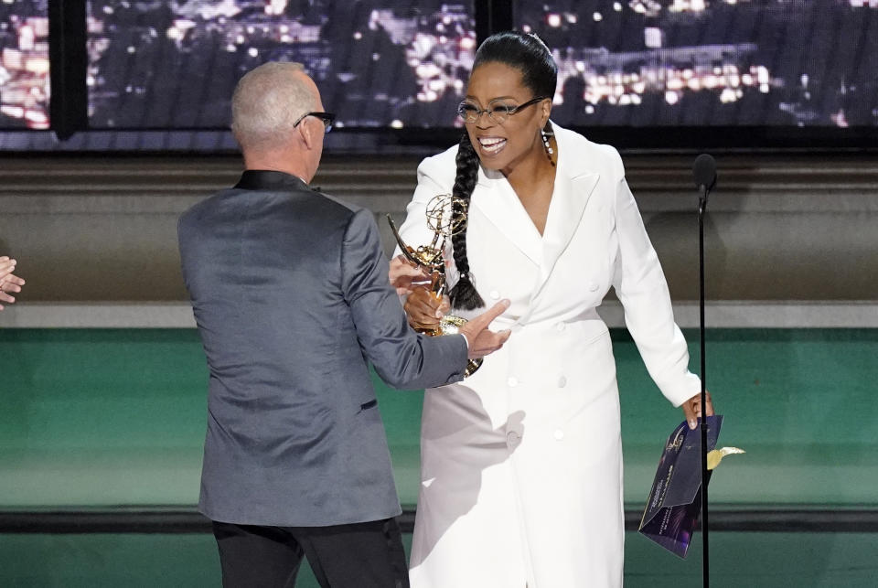 Oprah Winfrey, right, presents the Emmy for outstanding lead actor in a limited or anthology series or movie to Michael Keaton, left, for "Dopesick" at the 74th Primetime Emmy Awards on Monday, Sept. 12, 2022, at the Microsoft Theater in Los Angeles. (AP Photo/Mark Terrill)