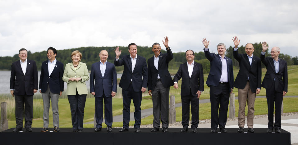 FILE - In this Tuesday, June 18, 2013 file photo, leaders from left, European Commission President Jose Manuel Barroso, Japan's Prime Minister Shinzo Abe, German Chancellor Angela Merkel, Russian President Vladimir Putin, British Prime Minister David Cameron, US President Barack Obama, French President Francois Hollande, Canadian Prime Minister Stephen Harper, Italian Prime Minister Enrico Letta and European Council President Herman Van Rompuy pose during a group photo opportunity at the G-8 summit at the Lough Erne golf resort in Enniskillen, Northern Ireland. Merkel has also been lauded as an impressive role model for girls both at home and around the globe for standing up to male leaders. (AP Photo/Matt Dunham, File)