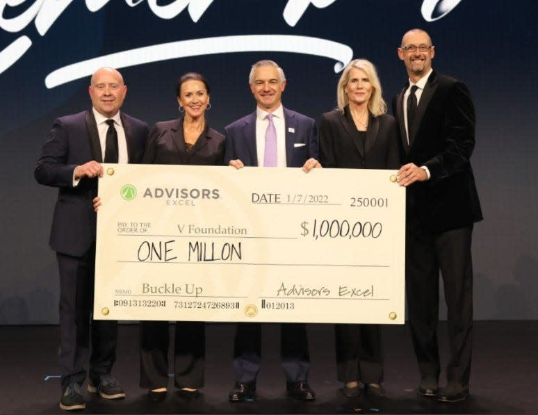 Advisors Excel co-founder Cody Foster, from left, Mary Kenealy, V Foundation CEO Shane Jacobson, Janet Allen and company co-founder David Callanan hoist $1 million check for the V Foundation on Jan. 7.