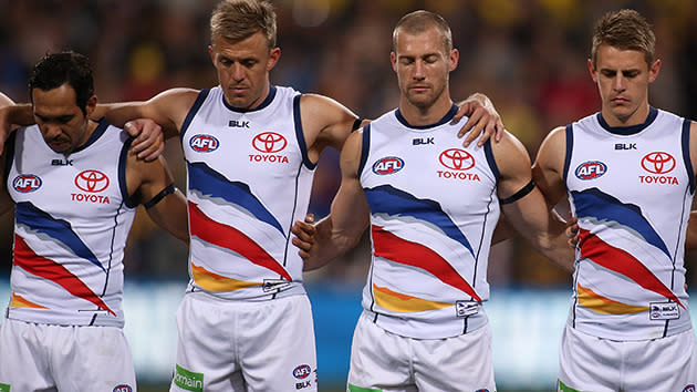 Crows players arm in arm.