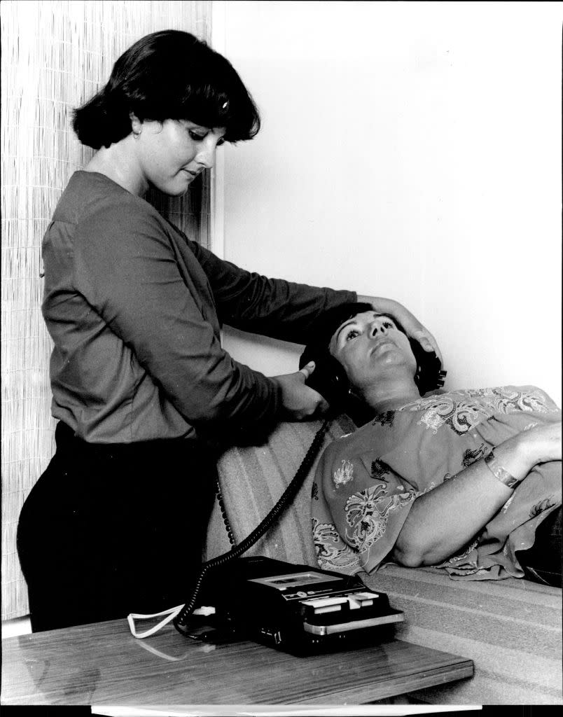 Dr. Chung’s receptionist, Louise Bench, sets up Mrs. Thelma Case in 1978 Sydney to listen to recordings about healthy living. (Credit: David James Bartho/Fairfax Media via Getty Images).