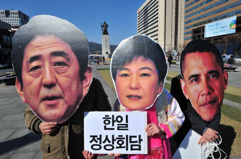 South Korean activists wear the masks of South Korean President Park Geun-Hye (C), Japanese Prime Minister Shinzo Abe (L) and US President Barack Obama (R) during an anti-government protest in Seoul on March 21, 2014