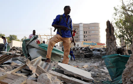 A security officer from Doorbin Hotel assesses the debris after a suicide car explosion in front of the hotel in Mogadishu, Somalia February 24, 2018. REUTERS/Feisal Omar