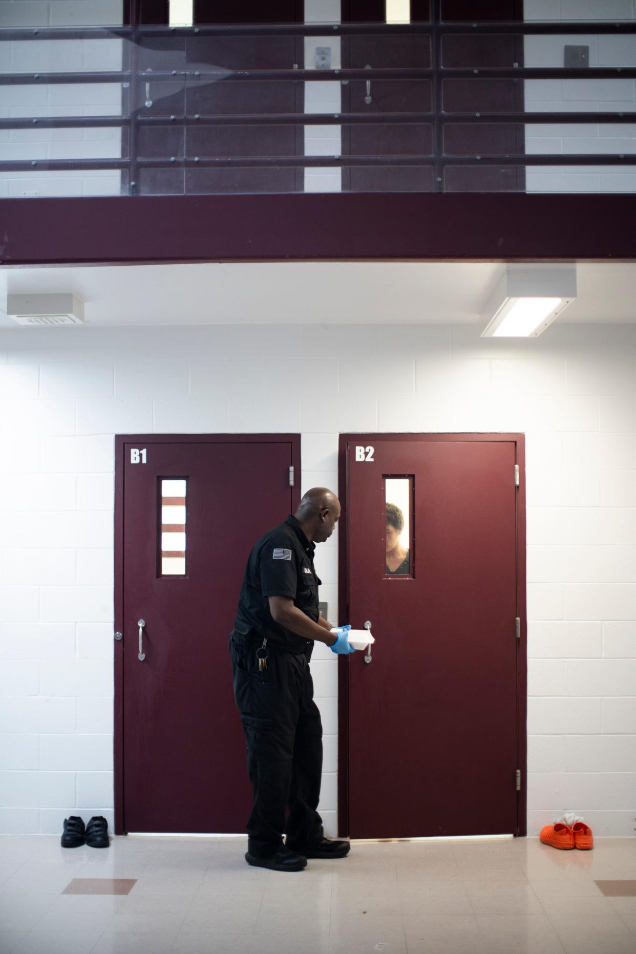 Sgt. Clifford Caldwell delivers a meal to a youth who prefers to eat alone, at the Multi-County Juvenile Detention Center in Lancaster, Ohio..