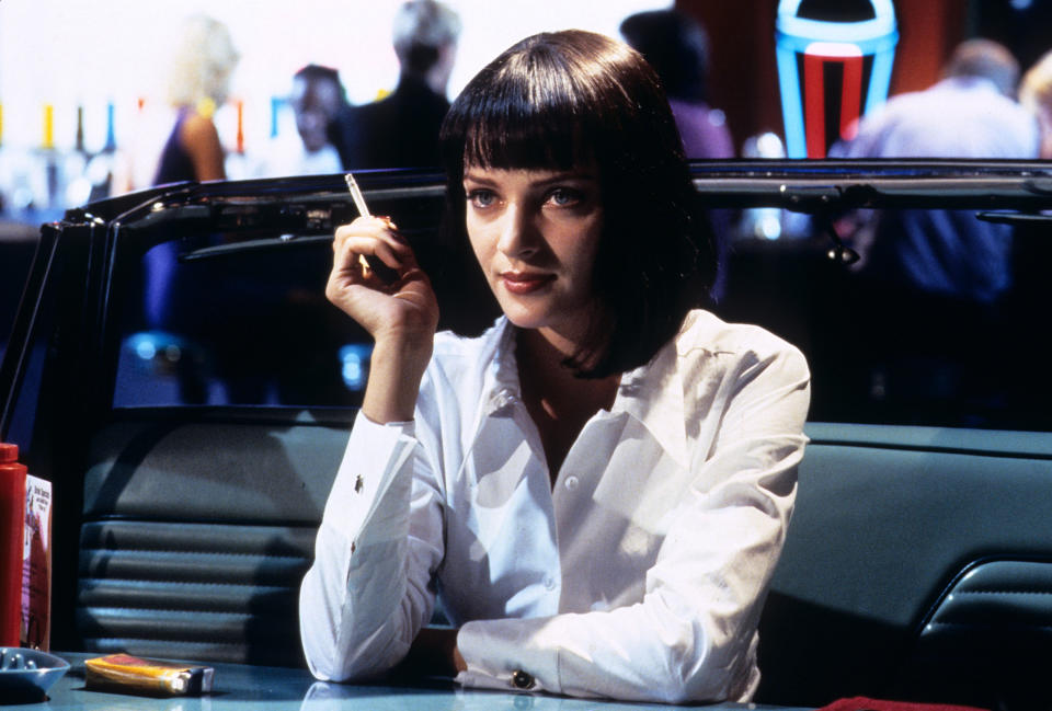 A woman smokes a cigarette at a table