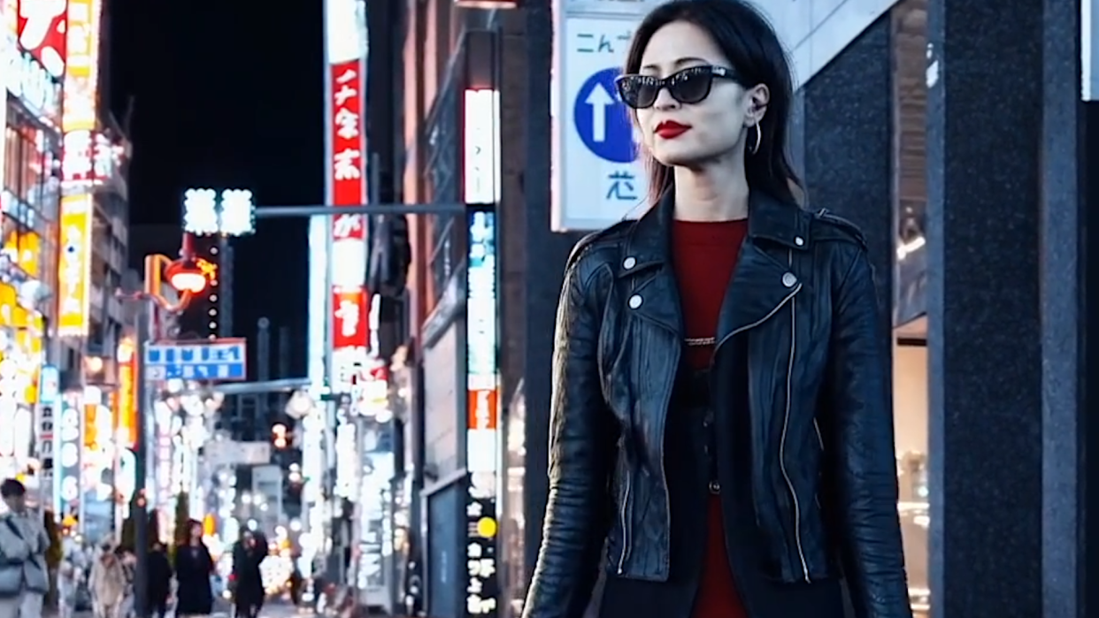  An image generated by Open AI's new Sora model of a woman wearing sunglasses in a vibrant cityscape. 