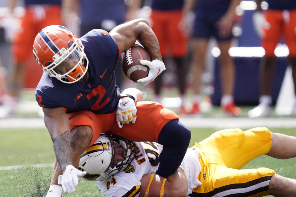 Wyoming nose tackle Cole Godbout tackles Illinois running back Chase Brown during the first half of an NCAA college football game, Saturday, Aug. 27, 2022, in Champaign, Ill. (AP Photo/Charles Rex Arbogast)