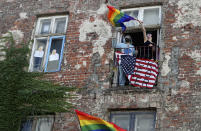 In this July 30, 2020 taken photo people occupied a house in support of LGBT protesters in Warsaw, Poland. LGBT people are choosing to leave Poland amid rising homophobia promoted by President Andrzej Duda and other right-wing populist politicians in power. On Thursday, with Duda to be sworn in for a second term as president, some LGBT people have already left Poland or are making plans to leave. (AP Photo/Czarek Sokolowski)