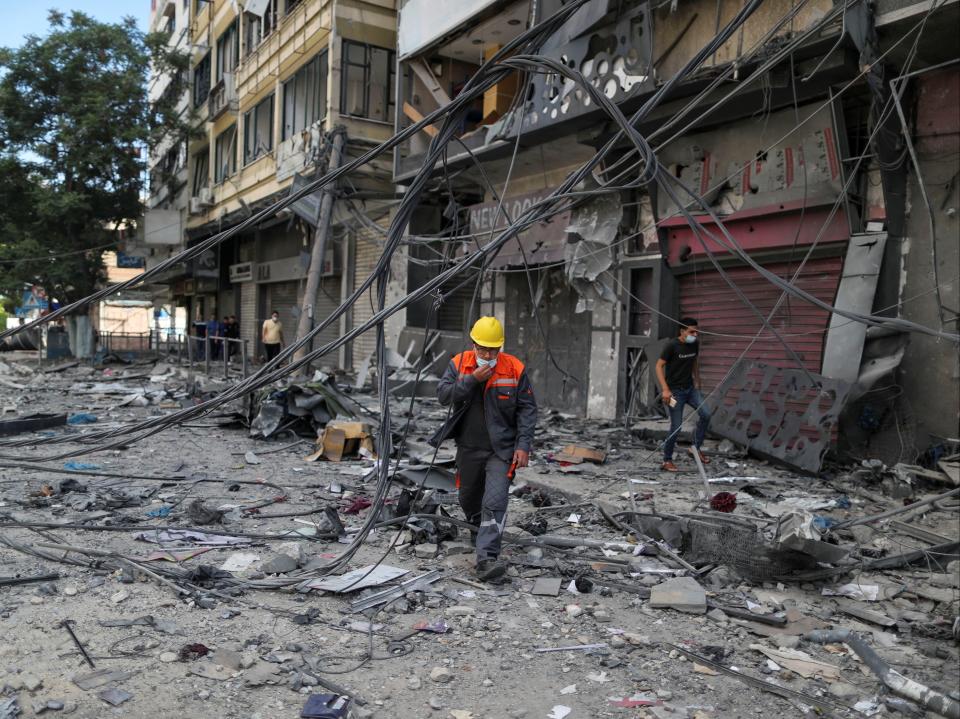 A Palestinian electricity worker walks at the site where a tower building was destroyed by Israeli air strikes, amid a flare-up of Israeli-Palestinian violence, in Gaza CitySuhaib Salem/Reuters