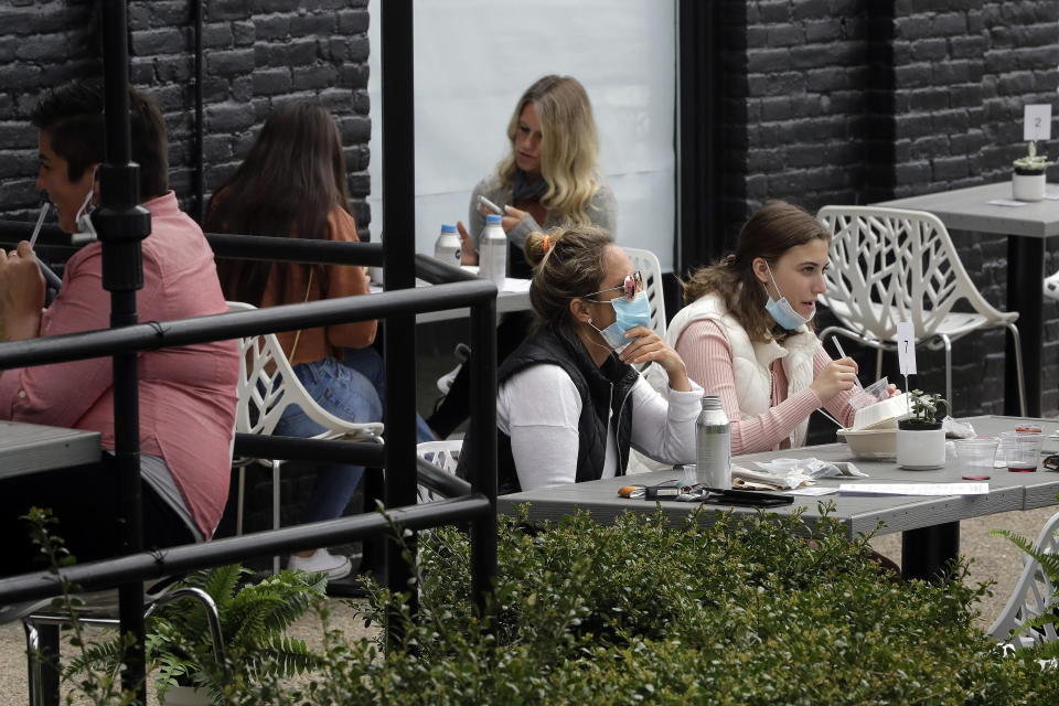 Patrons dine in an outdoor seating area at Plant City restaurant, Monday, May 18, 2020, in Providence, R.I. Rhode Island allowed restaurants to provide service with outdoor seated dinning Monday for the first time since the beginning of the government imposed lockdown due to the coronavirus pandemic. (AP Photo/Steven Senne)