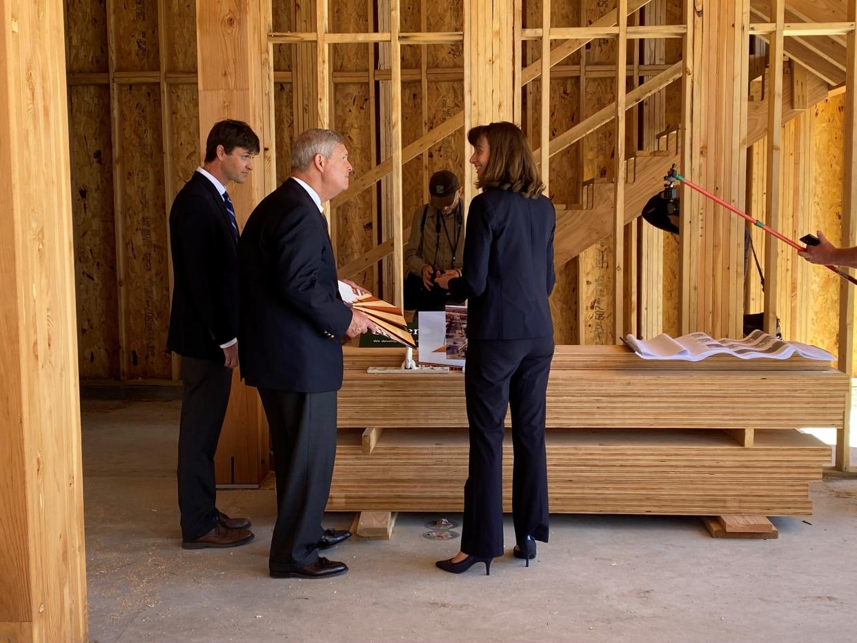 Developers Scott and Molly Cutler on Friday show U.S. Agriculture Secretary Tom Vilsack the mass timber product being used to build Junction Development Catalyst at 304 Fifth St. in West Des Moines' Valley Junction district.