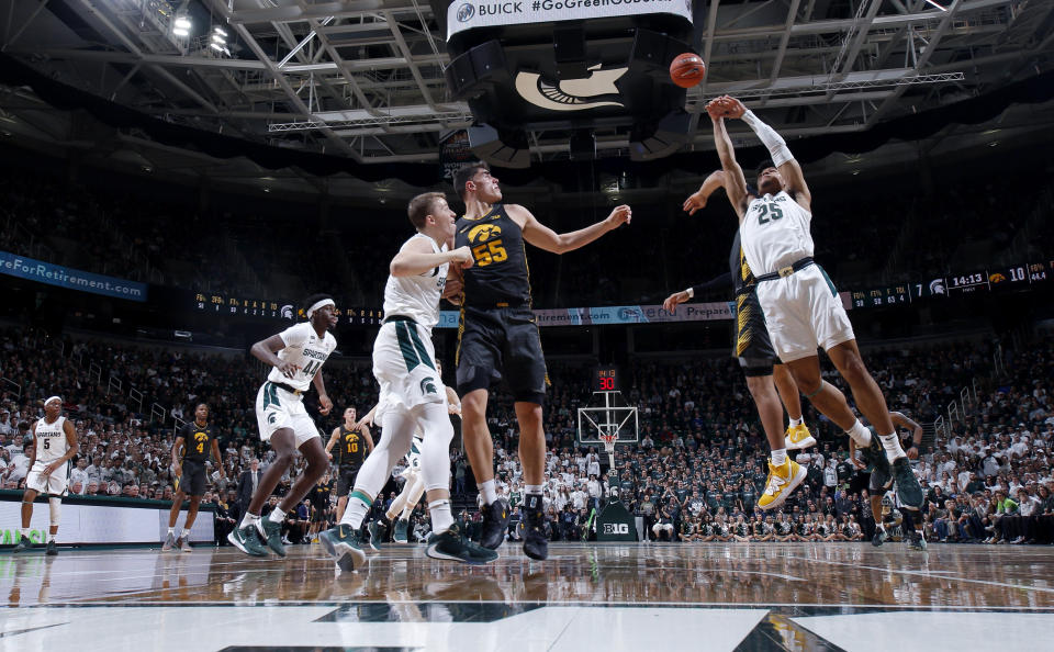 Michigan State's Malik Hall, right and Iowa's Luka Garza (55) and Michigan State's Thomas Kithier, left, vie for a rebound during the first half of an NCAA college basketball game, Tuesday, Feb. 25, 2020, in East Lansing, Mich. (AP Photo/Al Goldis)