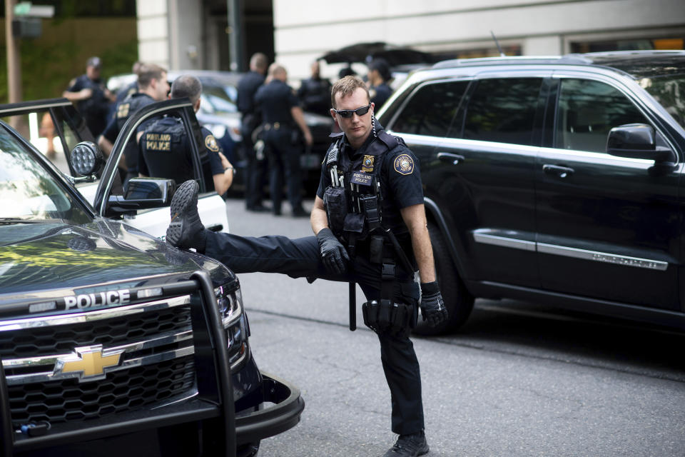 Portland police officer Bonczijk stretches before the start of a protest in Portland, Ore., on Saturday, Aug. 17, 2019. Police have mobilized to prevent clashes between conservative groups and counter-protesters who plan to converge in the city. (AP Photo/Noah Berger)