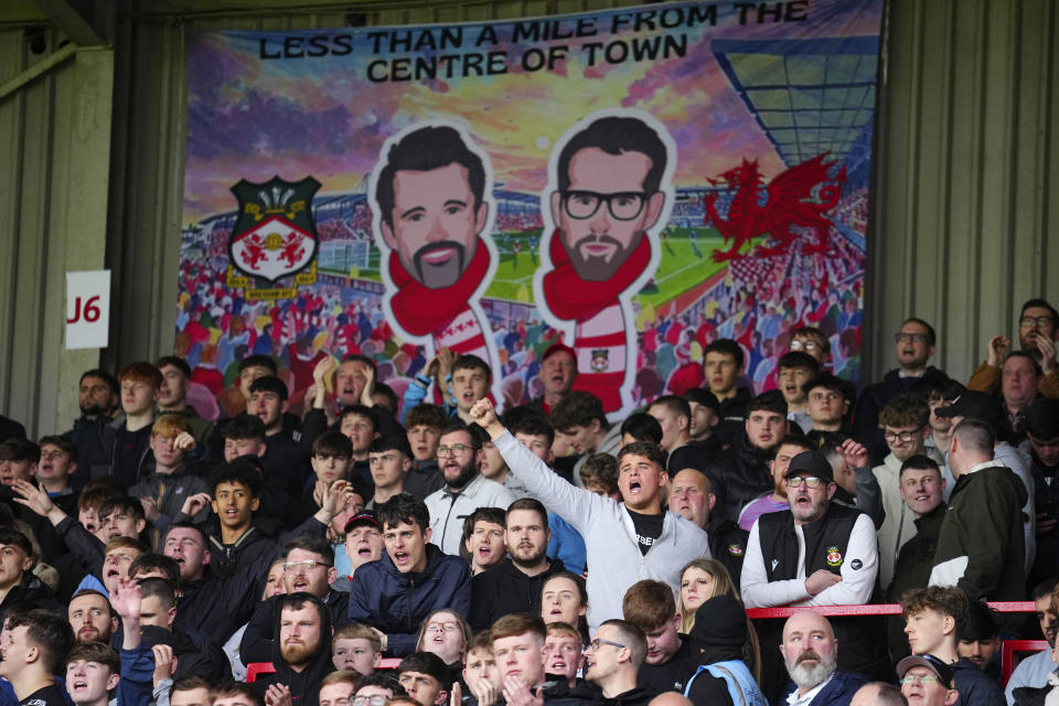 Wrexham supporters cheer during the English League Two soccer match between Wrexham and Stockport at the Racecourse Ground Stadium in Wrexham, Wales, Saturday, April 27, 2024.(AP Photo/Jon Super)