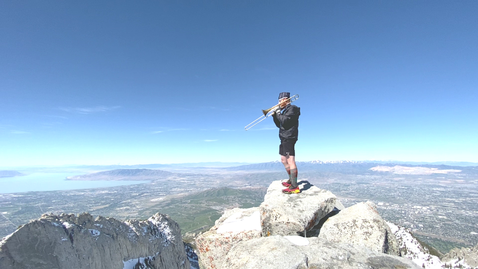 A man stands with his trombone on a mountain in a photo submitted to CBS News.  