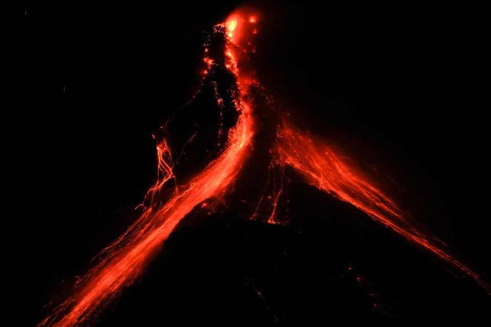 Lava flows down the slopes of Mayon volcano as seen from Daraga town, Albay province, northeastern Philippines, Tuesday, June 13, 2023. Truckloads of villagers on Tuesday fled from Philippine communities close to gently erupting Mayon volcano, traumatized by the sight of red-hot lava flowing down its crater and sporadic blasts of ash. (AP Photo/Aaron Favila)