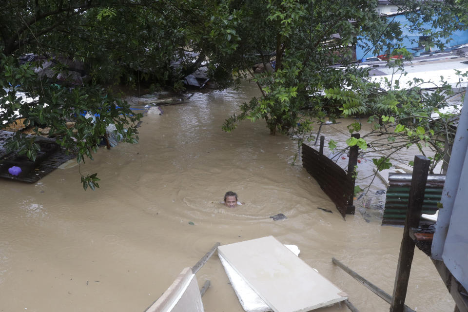 A man swims in neck deep floodwaters as it continues to rise in Marikina, Philippines, due to Typhoon Vamco on Thursday, Nov. 12, 2020. A typhoon swelled rivers and flooded low-lying areas as it passed over the storm-battered northeast Philippines, where rescuers were deployed early Thursday to help people flee the rising waters.(AP Photo/Aaron Favila)