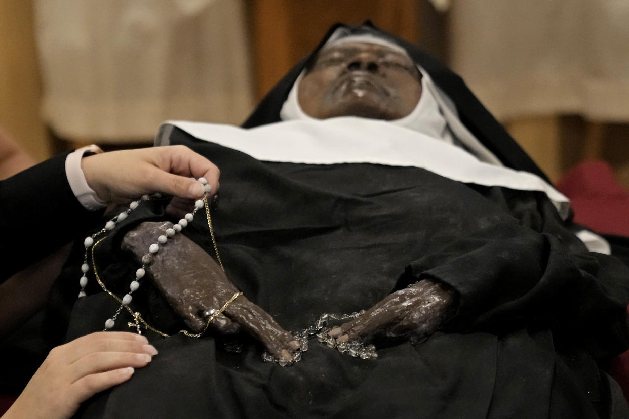 People pray over the body of Sister Wilhelmina Lancaster at the Benedictines of Mary, Queen of Apostles abbey. Hundreds of people visited the small town in Missouri this week to see the nun's body. Some are saying it's a sign of holiness in Catholicism, while others are saying the lack of decomposition may not be as rare as people think.  (AP Photo/Charlie Riedel)