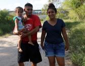 Honduran migrants Marvin Madrid and his new wife Dexy Maldonado walk along the Rio Bravo near an encampment in Matamoros