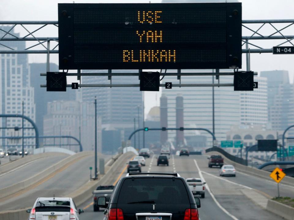 large black electronic sign reads "use yah blinkah" over a highway with cars