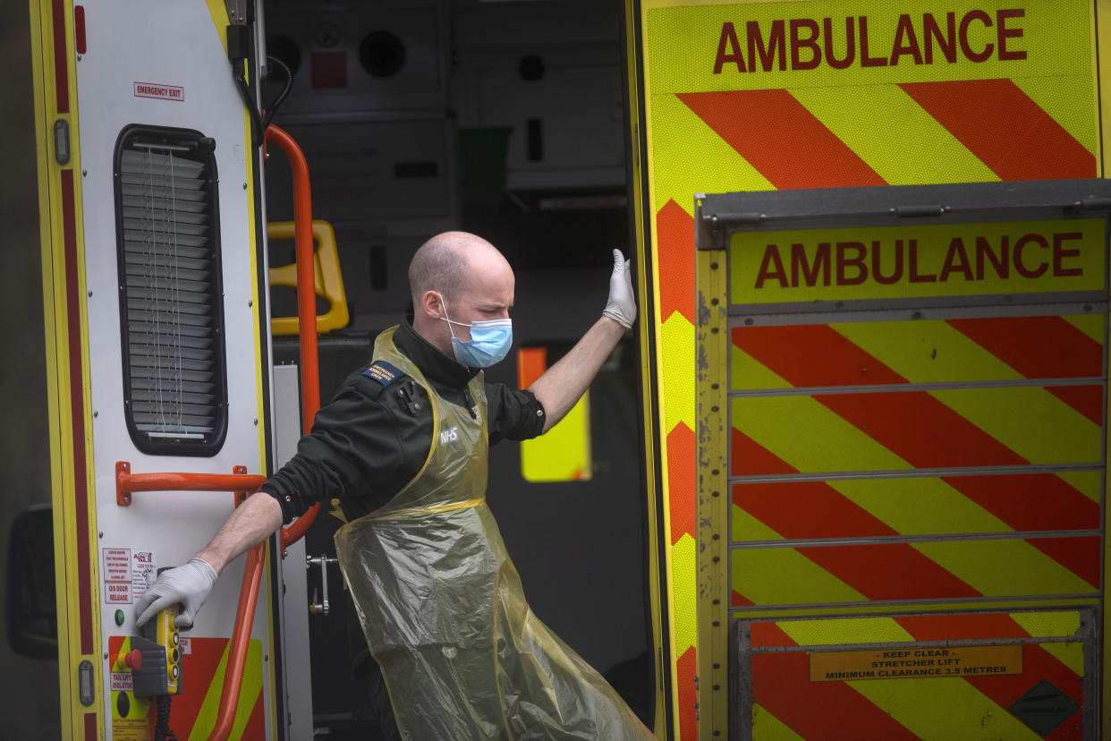 A London Ambulance worker wearing a protective face mask leaves an ambulance at St Thomas' Hospital in London as the UK continues in lockdown to help curb the spread of the coronavirus.