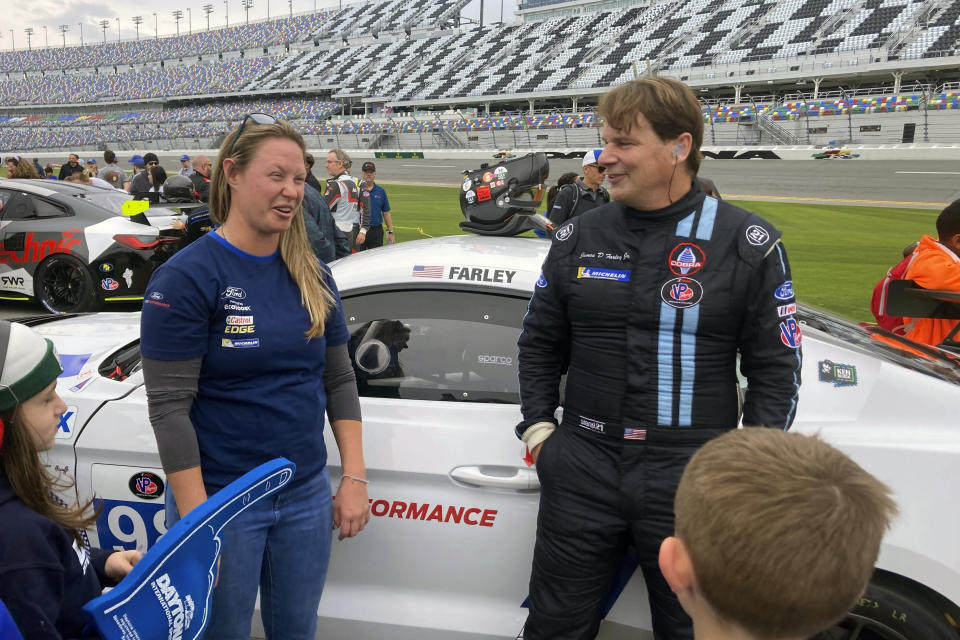 Ford CEO Jim Farley posing with fans on at Daytona International Speedway, Saturday, Jan. 21, 2023, in Daytona Beach, Fla., ahead of the IMSA Vo Racing SportsCar Challenge motor race. It was the professional racing debut for the 60-year-old chief executive of Ford Motor Co. He finished 12th. (AP Photo/Jenna Fryer)
