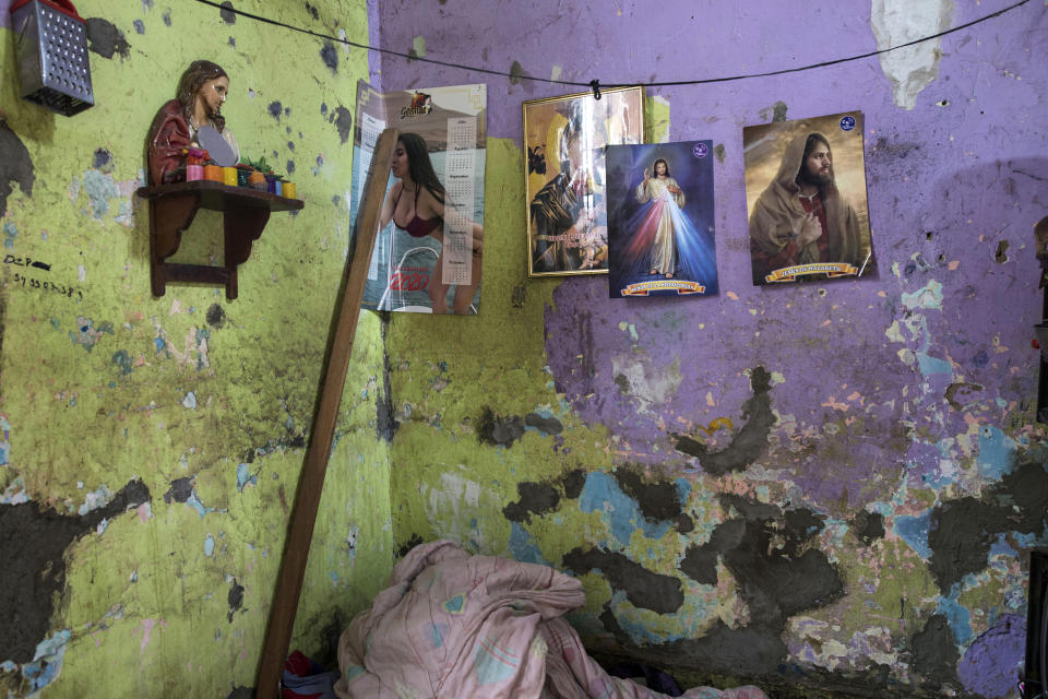 This March 26, 2020 photo shows the paint peeling on the cracked walls of Santos Escobar’s small room and his few belongings in a crumbling building nicknamed “Luriganchito” after the country’s most populous prison, where its residents have stories of hard luck and tough living, in Lima, Peru. Escobar, a 68-year-old former mug seller, ended up living in the shared house after his home burned down twice. In the first fire, two of his six daughters died; in the second, both his legs were burned. (AP Photo/Rodrigo Abd)