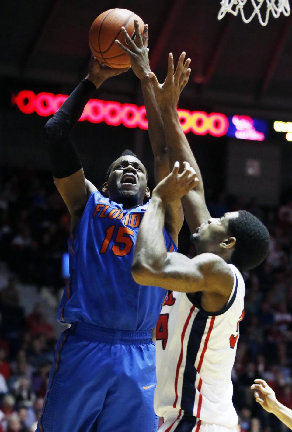 Florida forward Will Yeguete (15) attempts a shot while Mississippi forward Aaron Jones defends in the first half of an NCAA college basketball game in Oxford, Miss., Saturday, Feb. 22, 2014. (AP Photo/Rogelio V. Solis)