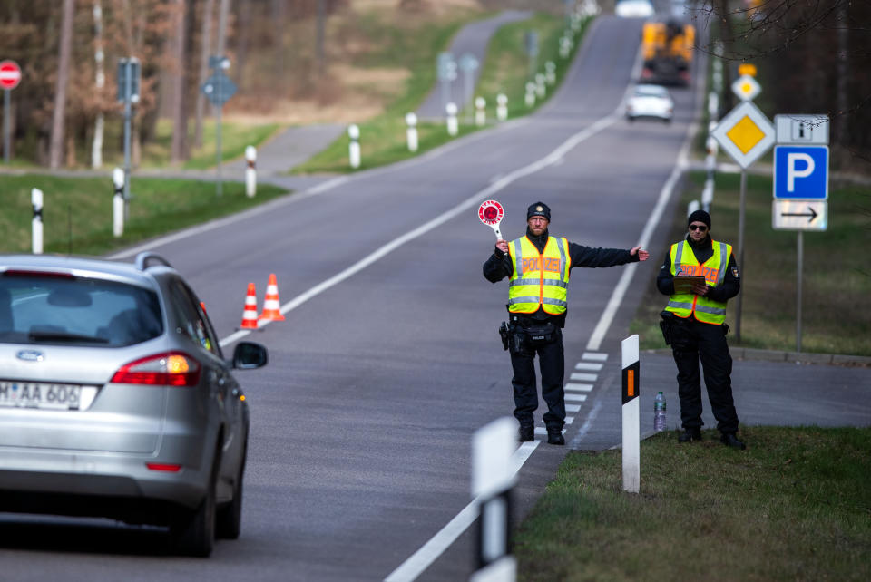 20 March 2020, Mecklenburg-Western Pomerania, Neustrelitz: On the federal road B96, police officers check vehicles that are not registered in Mecklenburg-Vorpommern. With the controls to contain Sars-CoV-2, the state government primarily wanted to prevent a further influx of tourists. Photo: Jens Büttner/dpa-Zentralbild/dpa (Photo by Jens Büttner/picture alliance via Getty Images)