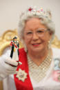 LONDON, ENGLAND - JANUARY 24: A Queen Elizabeth II look-a-like holds a queen chess piece part of a 'Studio Anne Carlton' set commemorating the Queen's Diamond Jubilee at the 2012 London Toy Fair at Olympia Exhibition Centre on January 24, 2012 in London, England. The annual fair which is organised by the British Toy and Hobby Association, brings together toy manufacturers with retailers from around the world. (Photo by Oli Scarff/Getty Images)