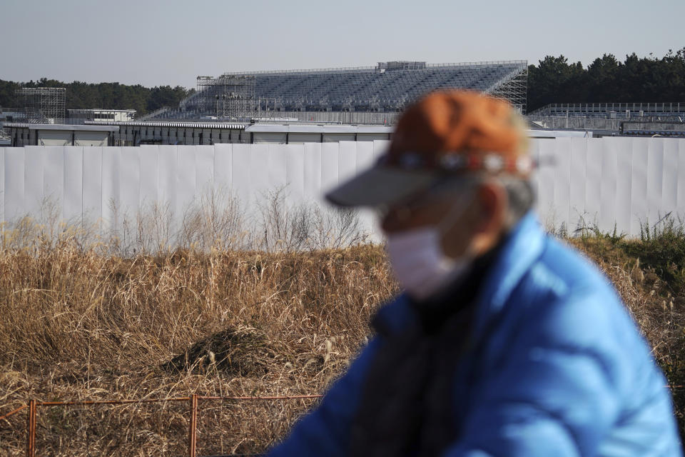 A man rides a bicycle past Canoe Slalom Course, one of the venues of Tokyo 2020 Olympic and Paralympic games, in Tokyo Thursday, Jan. 21, 2021. The postponed Tokyo Olympics are to open in just six months. Local organizers and the International Olympic Committee say they will go ahead on July 23. But it’s still unclear how this will happen with virus cases surging in Tokyo and elsewhere around the globe. (AP Photo/Eugene Hoshiko)